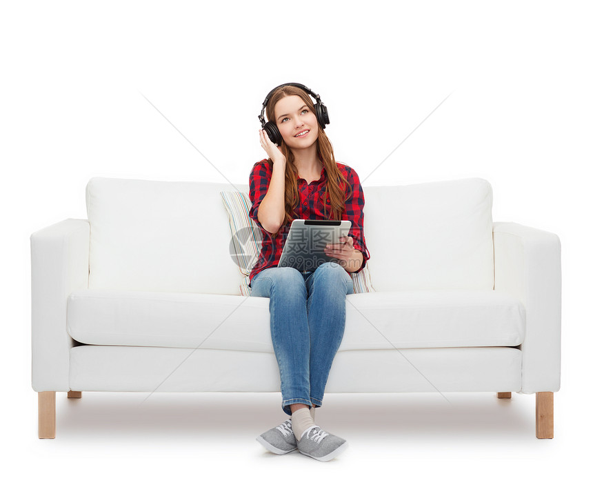 用耳机和平板电脑坐在沙发上的女孩青少年播客互联网技术微笑热情娱乐闲暇立体声打碟机图片