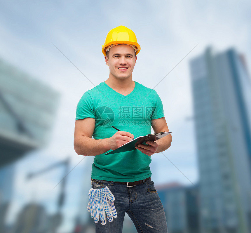 用剪贴板戴头盔微笑的男人男性承包商手套安全帽职员工程师写作城市维修建设者图片