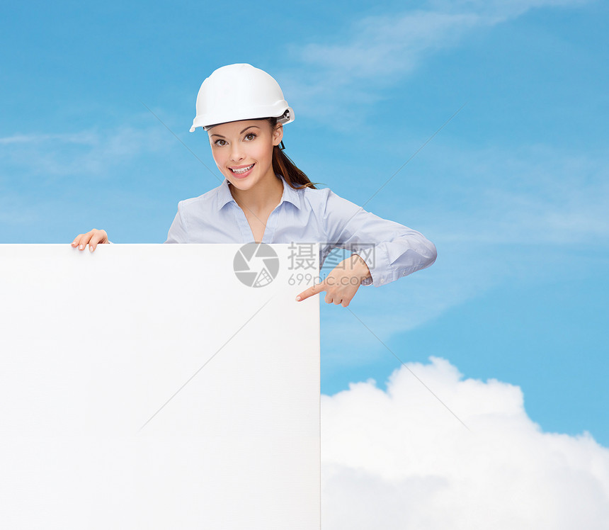 戴头盔的女商务人士用手指对着板拉丁天空承包商商务成人建设者女性木板财产建筑学图片