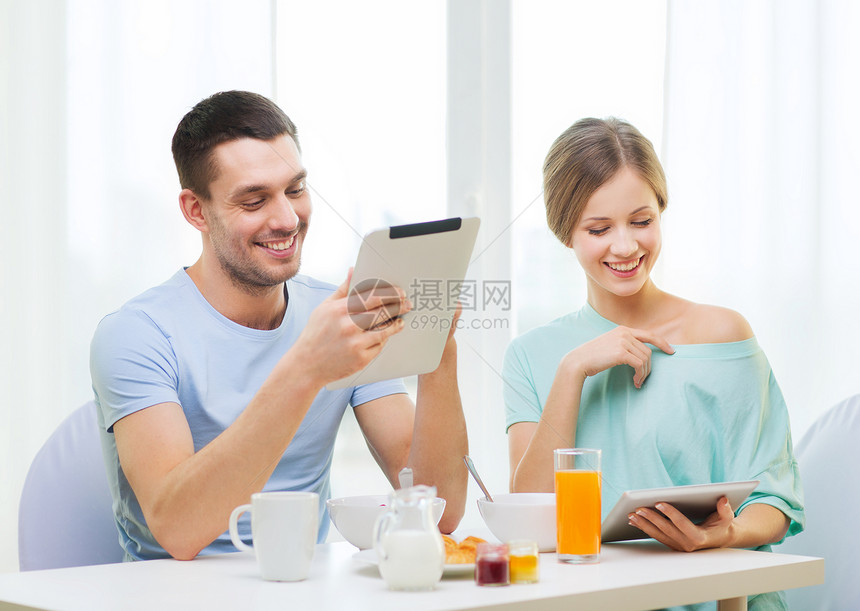 微笑的情侣与平板电脑Pc阅读新闻上网羊角家庭男人药片丈夫互联网面包咖啡女朋友图片