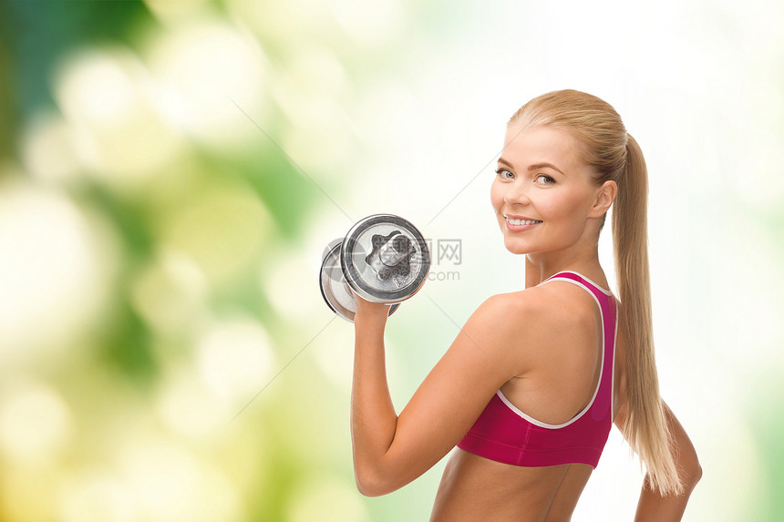 带着重钢的哑巴微笑的女人锻炼哑铃饮食力量重量损失训练女孩生物肌肉图片