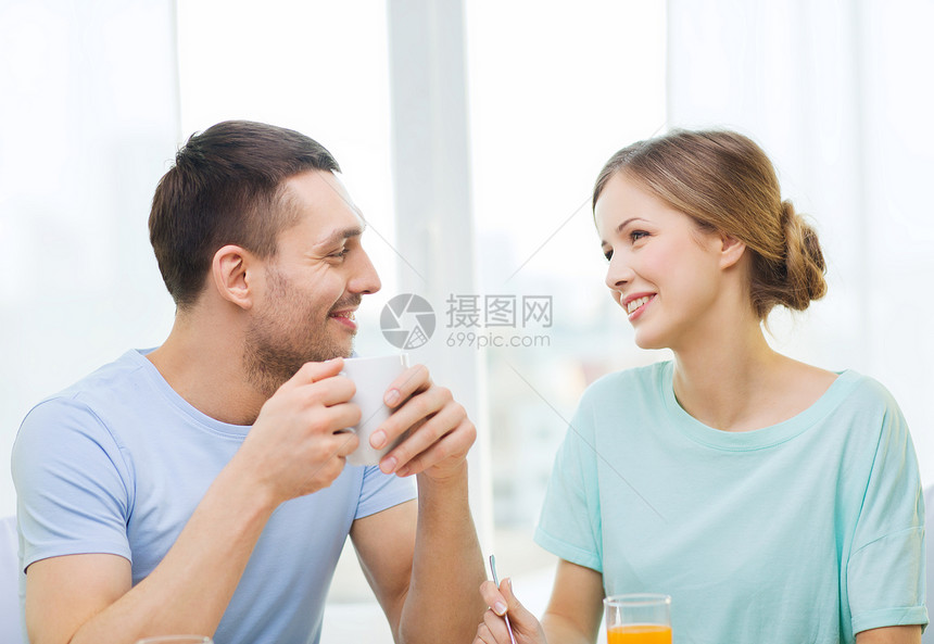 在家吃早餐时微笑的情侣杯子丈夫女士男朋友恋人女朋友快乐果汁女性家庭图片