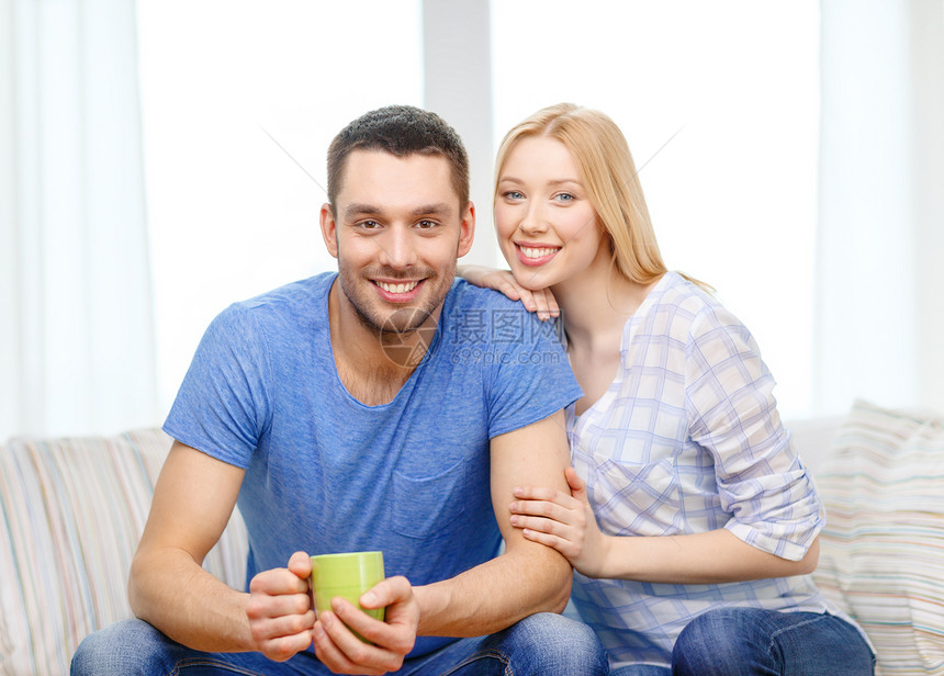 用茶杯或咖啡和妻子一起微笑的男人女性沙发成人女朋友房间女孩家庭饮料夫妻女士图片