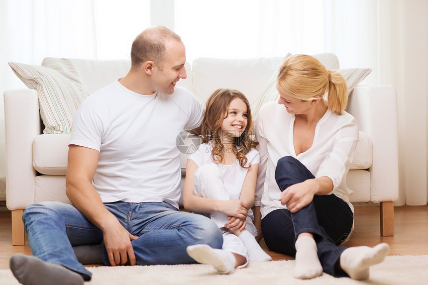 父母和小女孩坐在家中的地板上男性母亲家庭快乐青春期女性拥抱地面母性幸福图片
