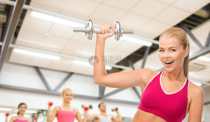 带着重钢的哑巴微笑的女人运动教练肌肉训练数字损失手臂减肥身体班级图片