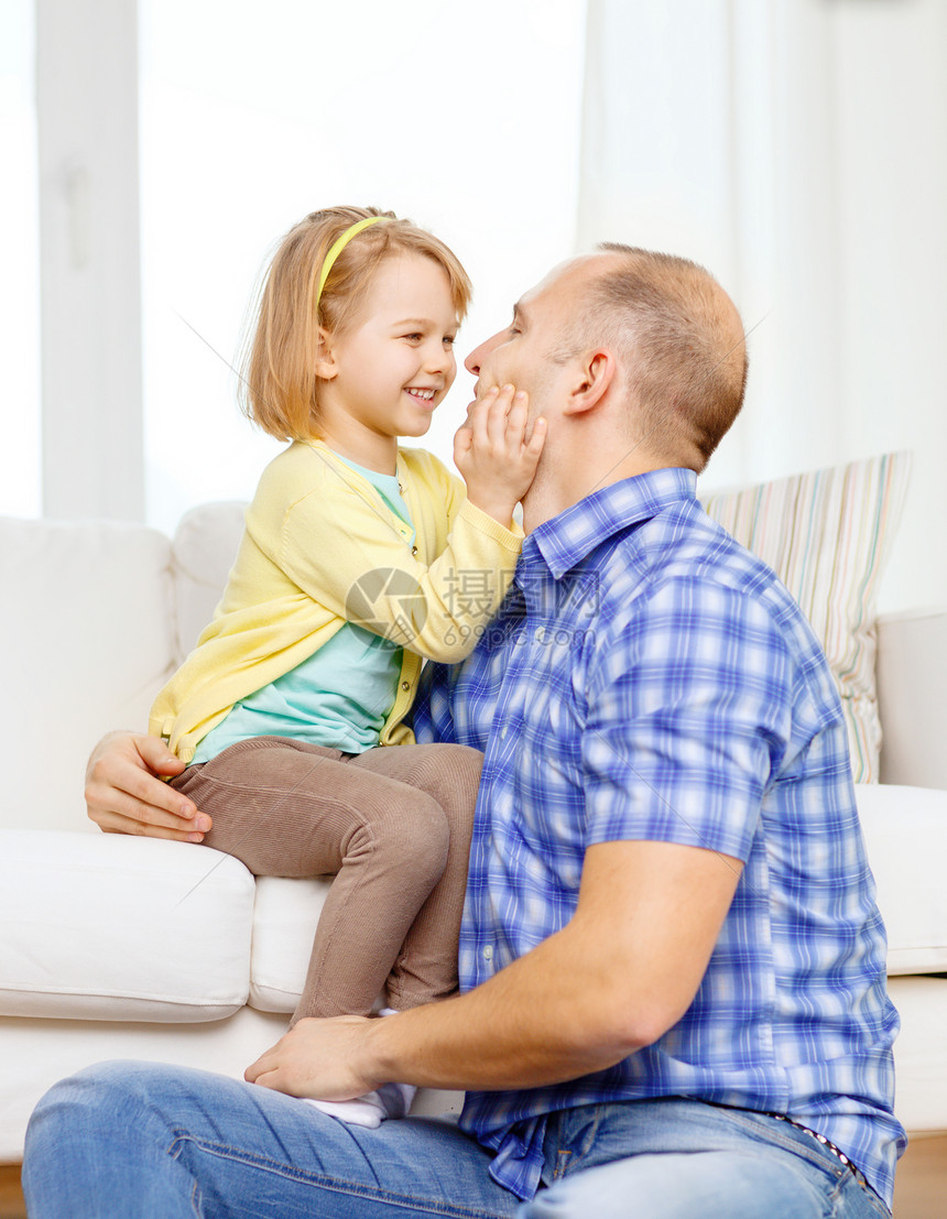 父亲和女儿在家中玩耍时笑着微笑父母女性房间房子地面家庭长椅孩子们拥抱孩子图片