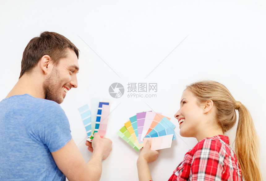 在家看彩色样本时微笑的一对夫妇房间调色板公寓成人改造装修夫妻男人样品女士图片