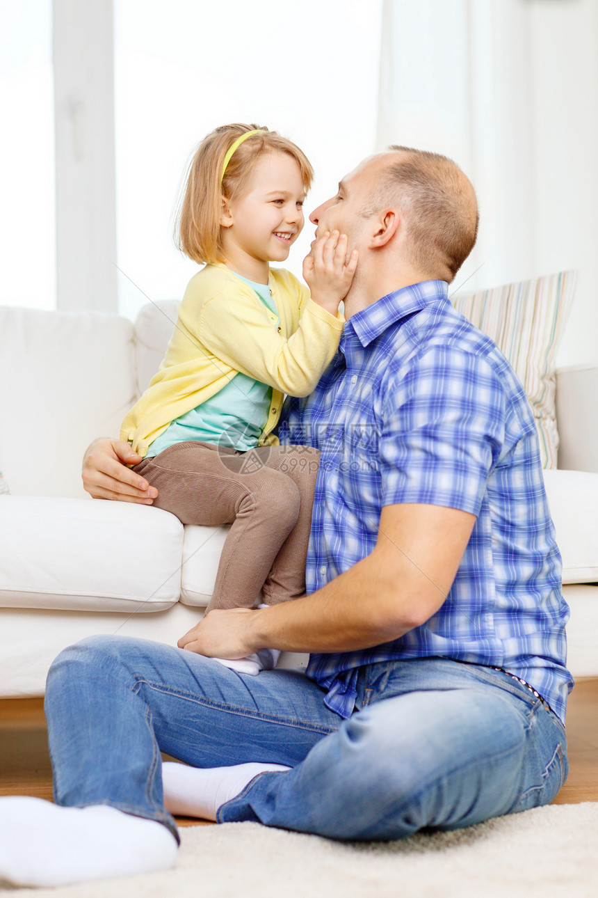 父亲和女儿在家中玩耍时笑着微笑女性房子父母沙发家庭成人房间男人男性幸福图片