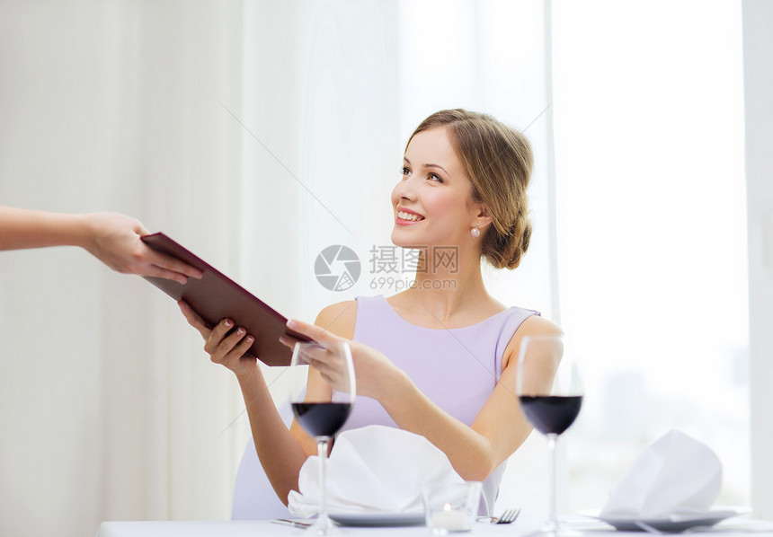 微笑着的女士给餐厅服务员提供菜单图片