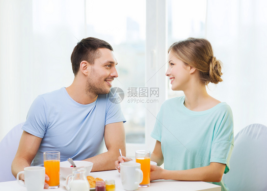 在家吃早餐时微笑的情侣面包厨房食物果汁成人女朋友家庭幸福杯子咖啡图片