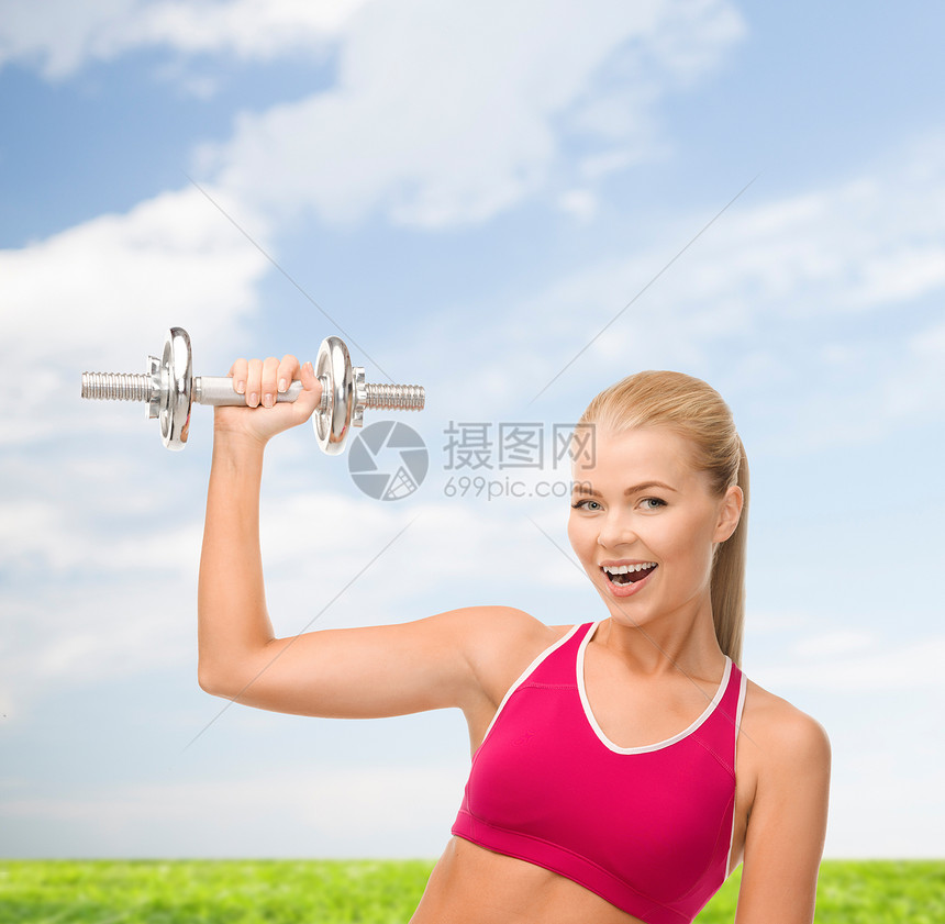 带着重钢的哑巴微笑的女人损失蓝色光盘身体健身房减肥肌肉运动装天空运动图片