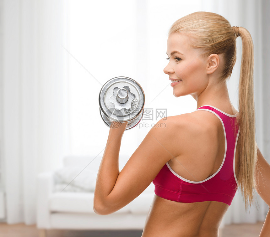 带着重钢的哑巴微笑的女人沙发减肥肌肉饮食锻炼运动训练运动装健康哑铃图片