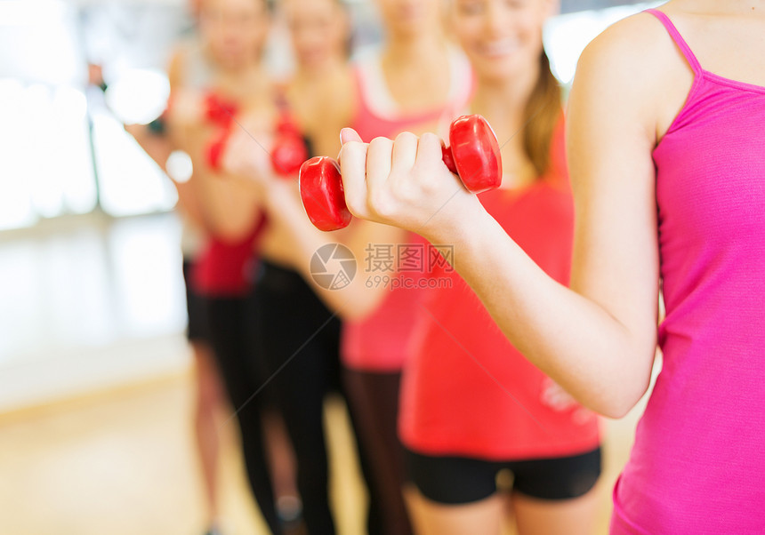 在健身房和哑铃一起工作的一群人二头肌朋友们女性团队手臂运动装团体运动护理力量图片