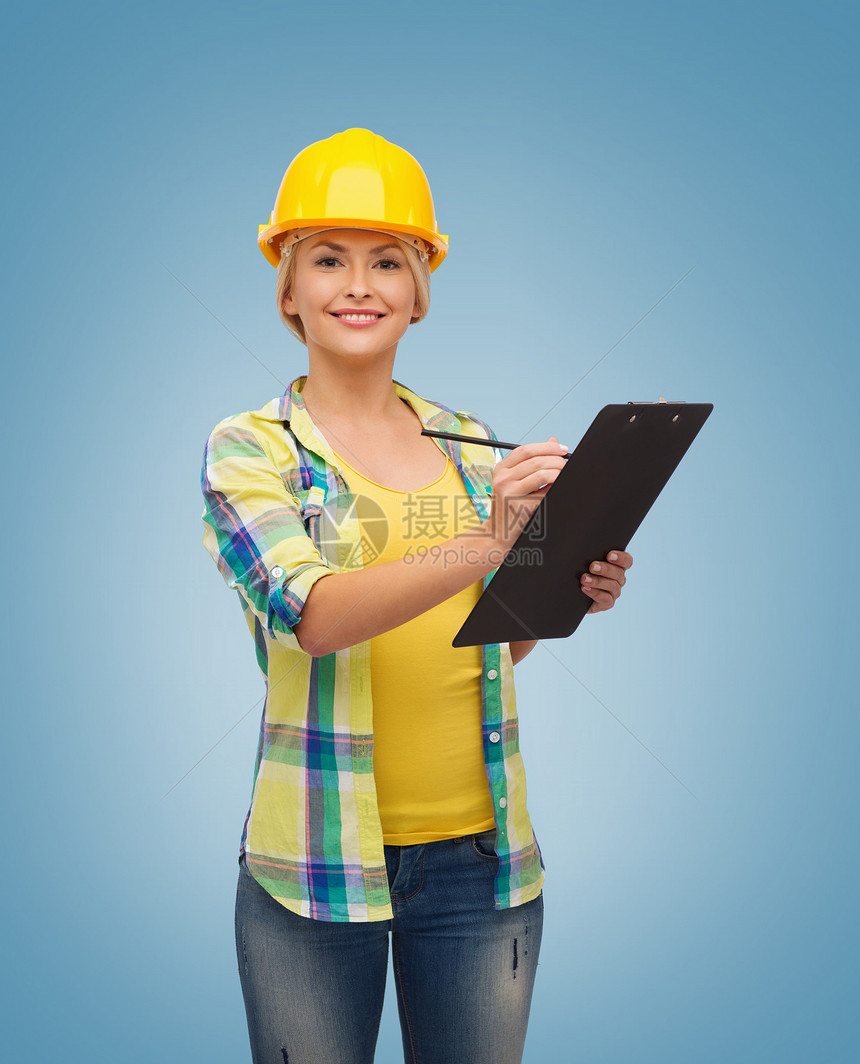 带着剪贴板戴头盔的笑着女人蓝色安全帽女士建筑职员建设者成人承包商专家职业图片