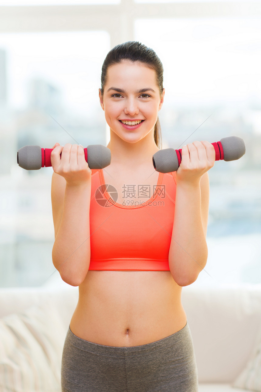 笑着的少女与哑铃女一起运动健身房训练重量抽水减肥权重成人运动装女孩女士图片