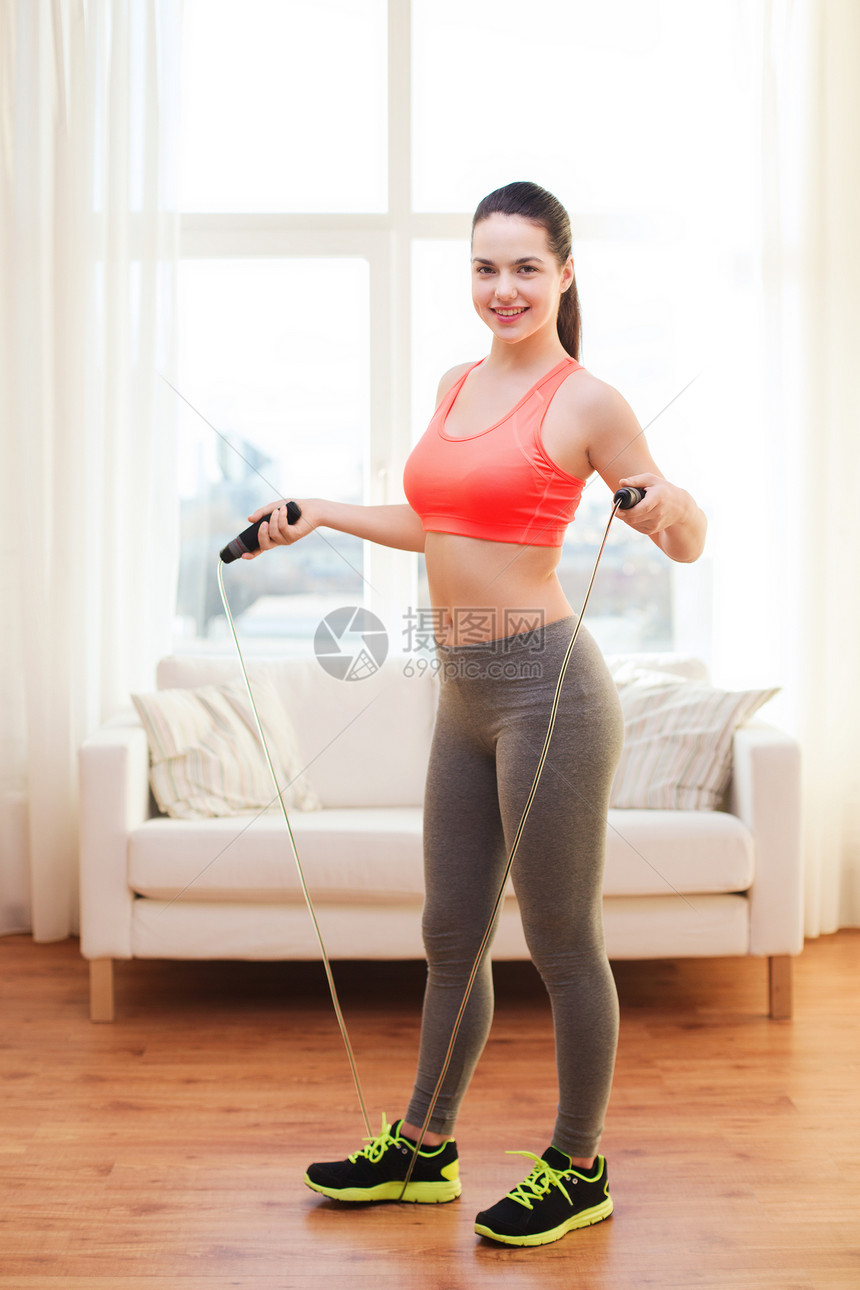 微笑着的少女 在家里跳绳运动装有氧运动青少年训练女性跳跃房间肌肉拉丁重量图片