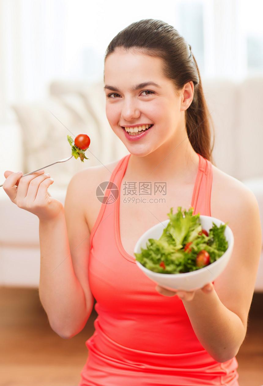 带着绿色沙拉的笑着微笑的少女女孩素食主义者喜悦食物女性运动装营养蔬菜青少年锻炼沙拉图片