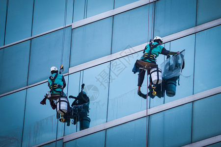 建筑清洁工高楼的清洁窗户服务工人群体在高楼大楼内打扫窗户服务网格场景安装玻璃财产城市水器维修镜子反射背景