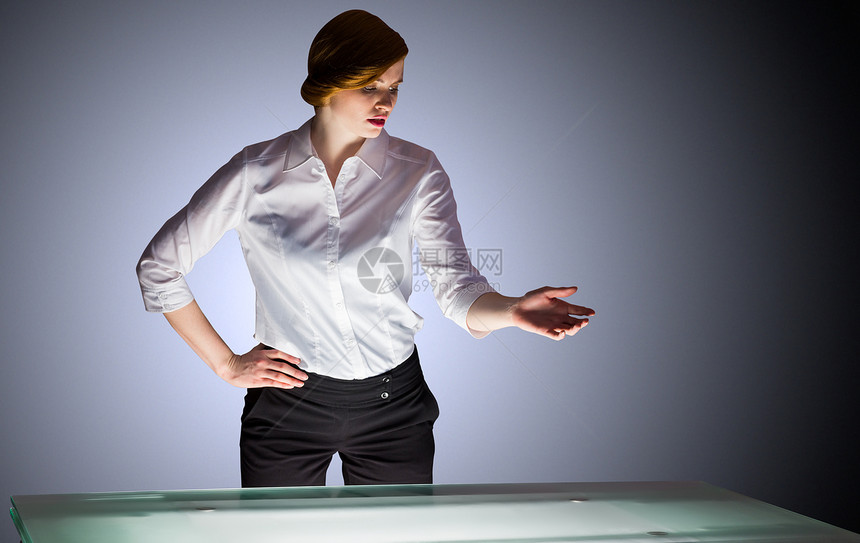 红头女商务人士站在一个办公桌旁和看管着商务桌子衬衫商业职业女士红发女性手势人士图片