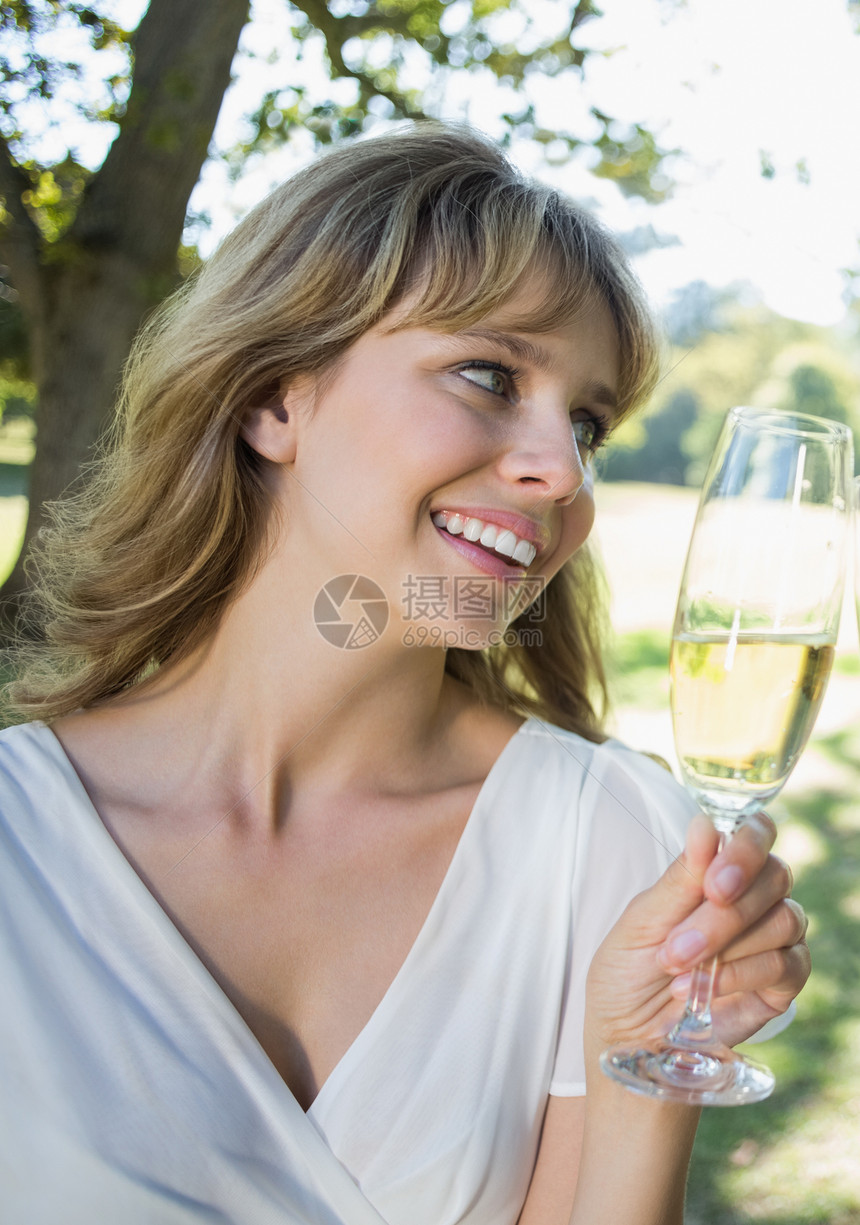 金发美女坐在外边 喝着香槟敬酒图片