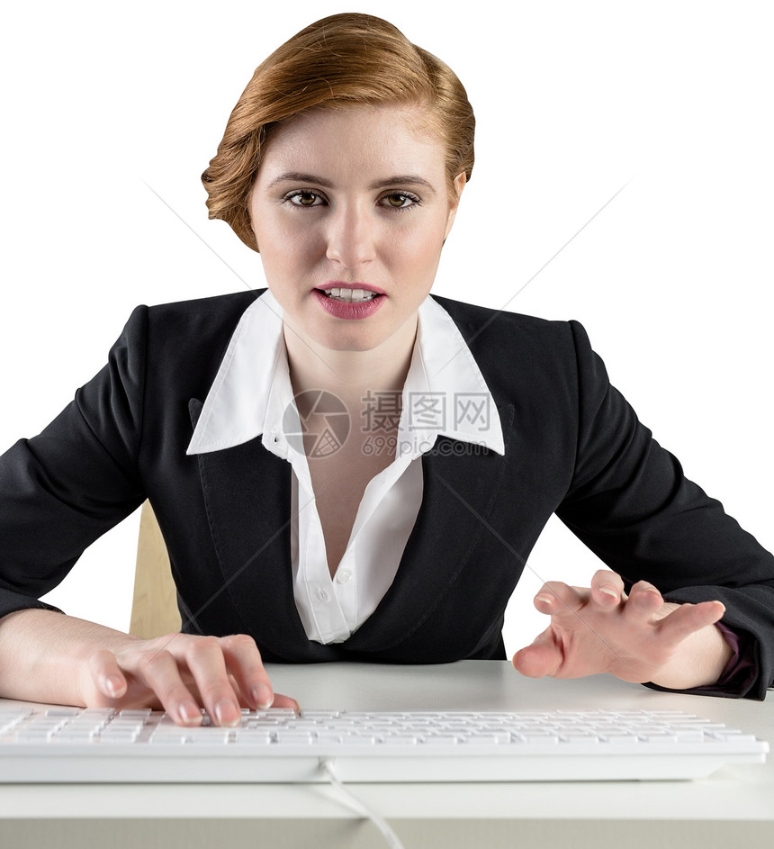 坐在案头打字的红头女商务人士人士专注职业键盘女性桌子女士红发公司商业图片