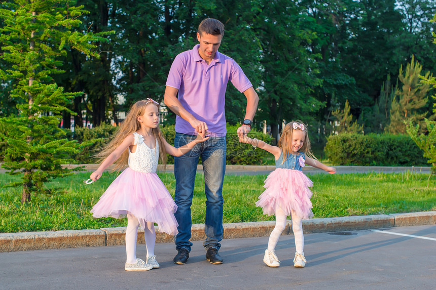 年轻爸爸和他的可爱女儿 在户外玩得开心微笑孩子们婴儿成人女孩喜悦孩子草地闲暇公园图片