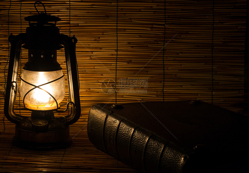用旧生锈的灯笼和一本书蜡烛金属玻璃火焰阴影阅读艺术黄铜燃料红色图片