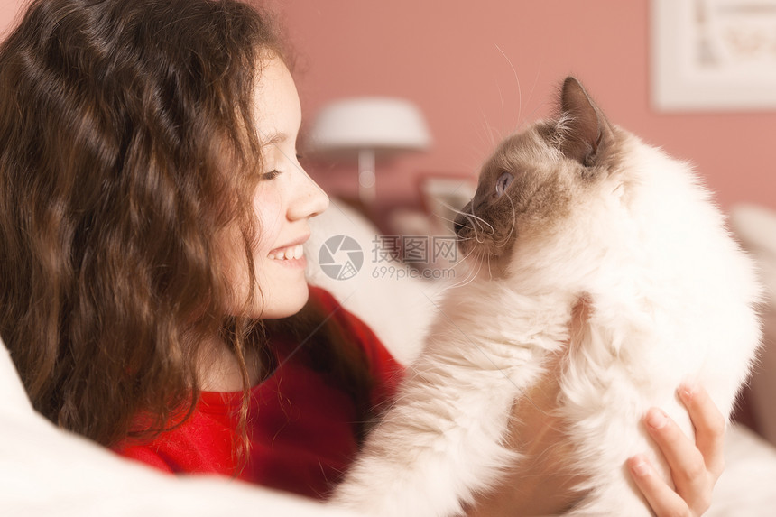 带着猫咪的年轻女孩孩子们压痛白色孩子快乐友谊青少年幸福沙发红色图片