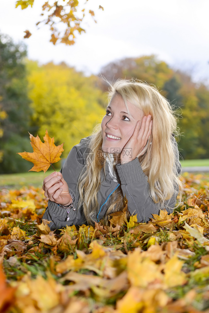 休秋假的妇女长发金发女郎金发公园快乐乐趣女性微笑青年树叶图片