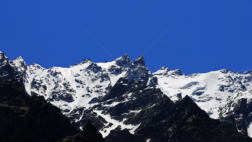 雪下和清蓝天空下的高加索山脉旅行天蓝色天空石头旅游高山生长爬坡滑冰季节图片