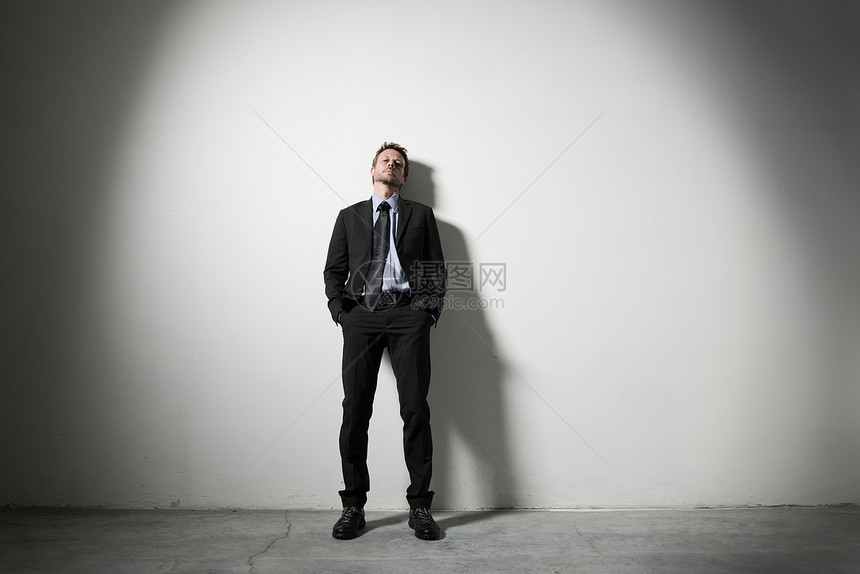 商务人士靠在墙上商务口袋个性倾斜戏剧性人士男人男性沉思虚荣图片