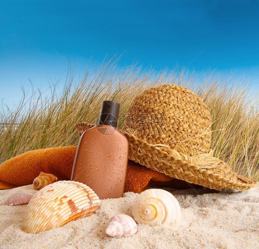 沙滩上用毛巾扎帽乐趣沙丘闲暇旅行钱包季节蓝色洗剂休闲旅游图片