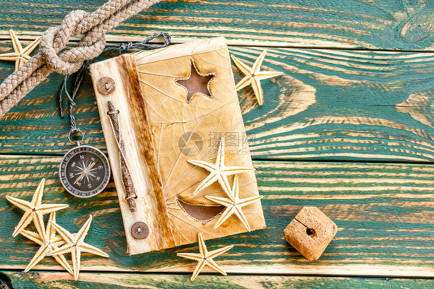 甲板上贴有贝壳的旧笔记本贝类字帖职业杂志日志木头木板星星风化剥离图片