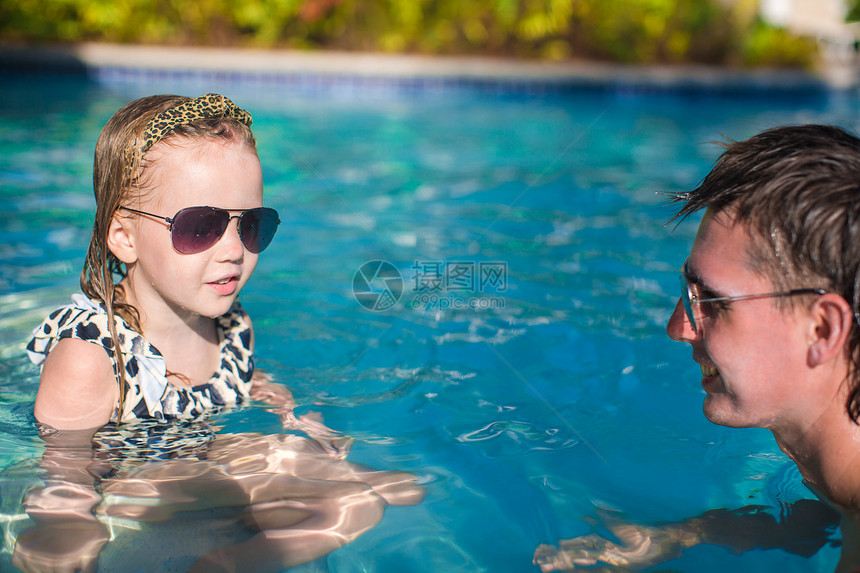 幸福的家庭在游泳池里放松热带男人乐趣游泳蓝色女孩飞溅爸爸游泳者喜悦图片