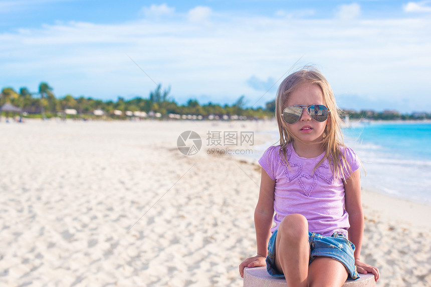 坐在异国海滩的莲花沙滩上的可爱的小姑娘假期童年身体婴儿赤脚女孩海洋幸福蓝色姿势图片