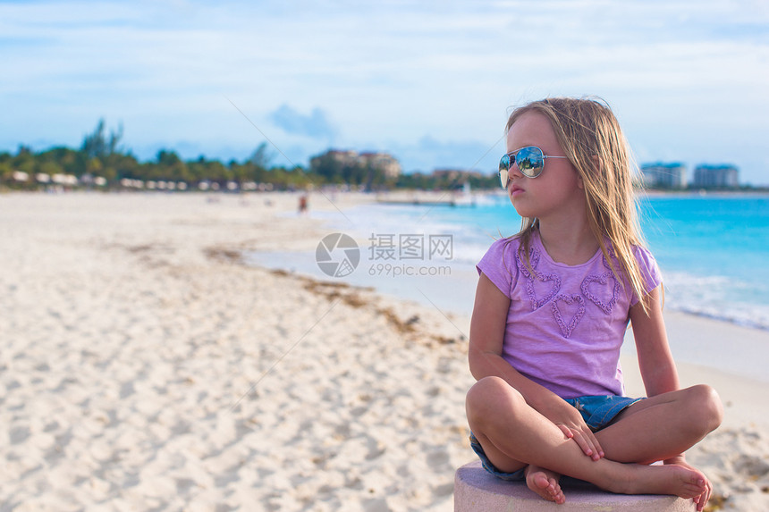 坐在异国海滩的莲花沙滩上的可爱的小姑娘女孩赤脚婴儿海滨幸福情调身体热带海岸蓝色图片