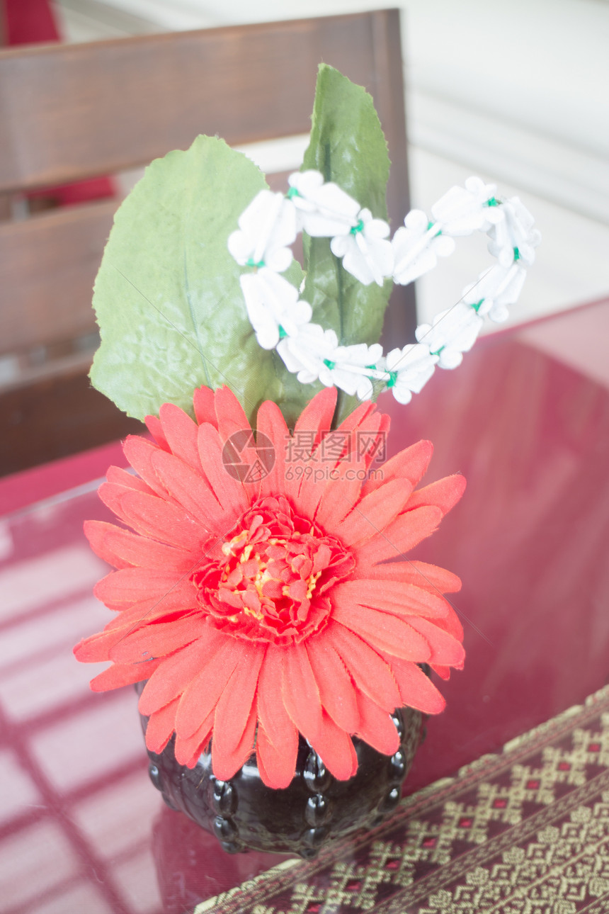 桌子上装饰的红黄芝贝拉花朵图片