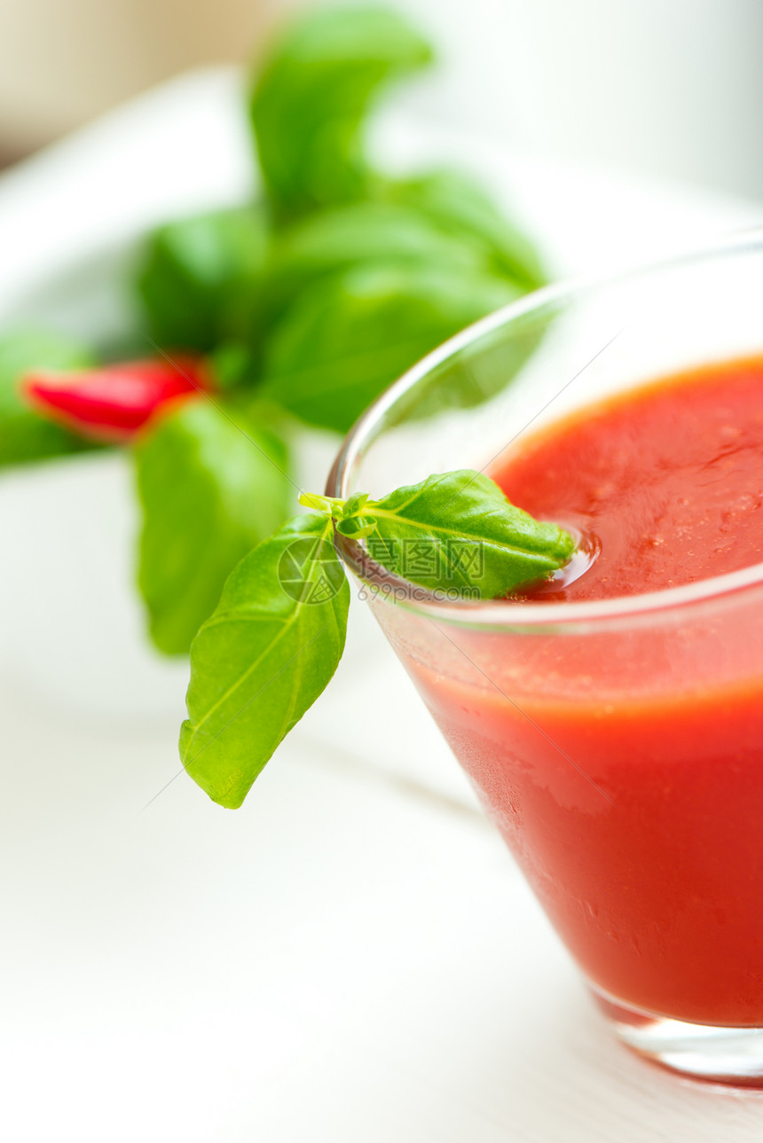 白木桌背景的番茄汁液体白色玻璃水果绿色红色食物叶子果汁香菜图片