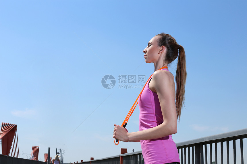 运动 有吸引力的女孩跳过绳索有氧运动街道运动装身体衣服公园女性阳光青年太阳图片