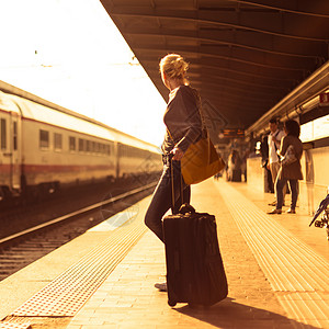 包平台素材女士在火车站等着呢民众金发女郎乘客女性手提箱假期平台时间过境城市背景