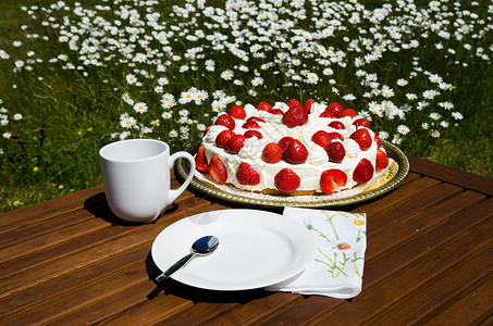 草莓杯子蛋糕配草莓蛋糕和咖啡杯的桌子背景