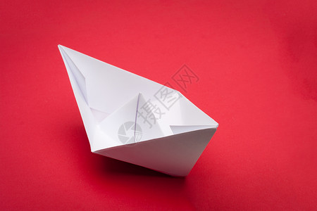 折纸船白色自由玩具血管折叠旅行航行折纸工作室红色背景图片