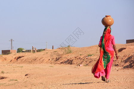 滕头村在Khichan村 当地妇女头顶上带水的罐子背景