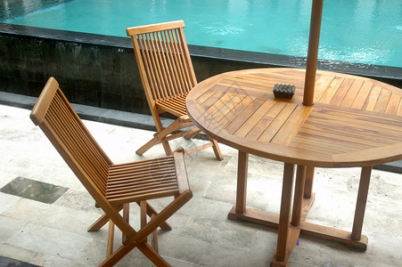 游泳池棕色椅子白色酒店蓝色装饰品背景图片