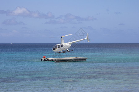 直升机飞行运输蓝色天空转子浮桥叶片海洋背景图片