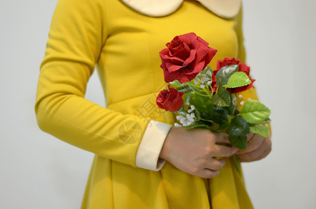 女人穿着黄色的礼服 有红玫瑰女孩庆典礼物裙子连衣裙玫瑰幸福女性背景图片