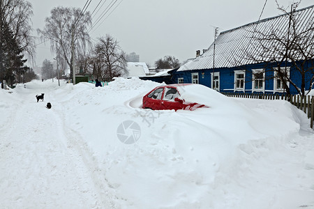 红色小城雪暴后被雪雪覆盖的红色车背景