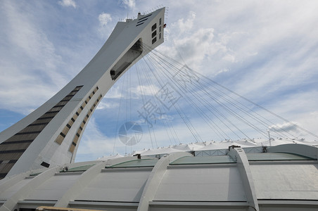 加拿大蒙特利尔奥林匹克运动会体育场水泥建筑学地标棒球倾斜蓝色建筑电梯竞赛旗帜背景图片