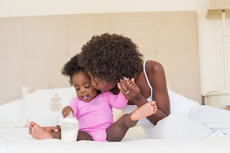 父母在床上带着女婴的快乐女性棉被家庭生活羽绒被女士感情幸福家庭婴儿房子背景图片