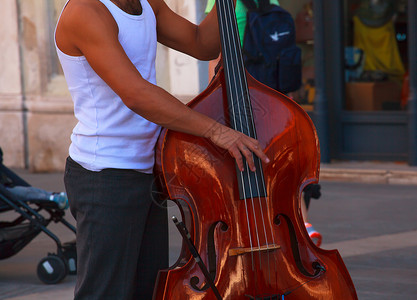 街头音乐家玩双低音艺术家节日居住城市音乐观众和弦爵士乐乐队街道背景图片